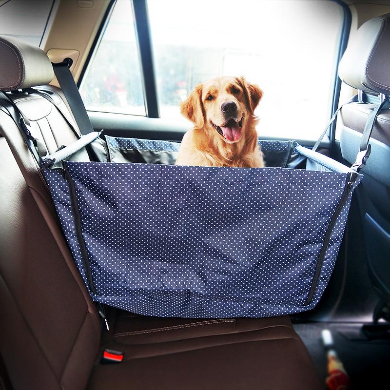 Golden retriever sitting in a blue waterproof dog car hammock on a back seat