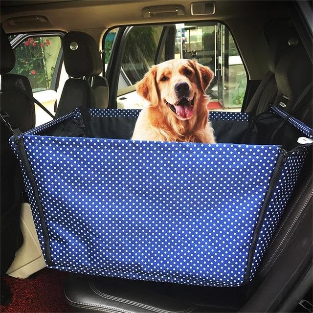 Golden retriever sitting in a blue polka dot waterproof dog car hammock